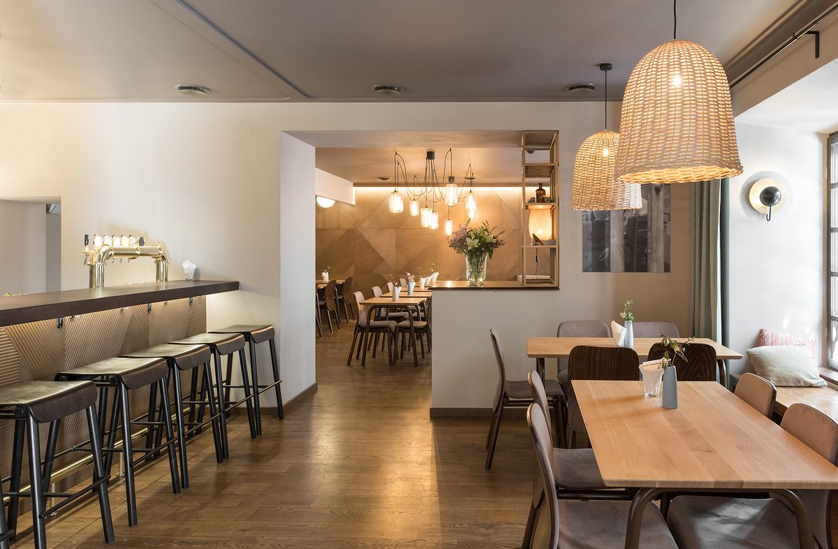 Stylish lamp shining over small tables and comfortable chairs in cozy restaurant