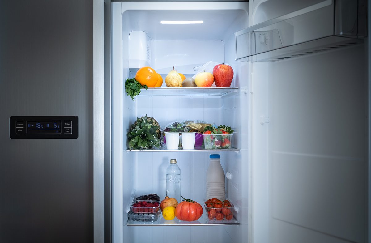 Shelf of refrigerator full of healthy food at home