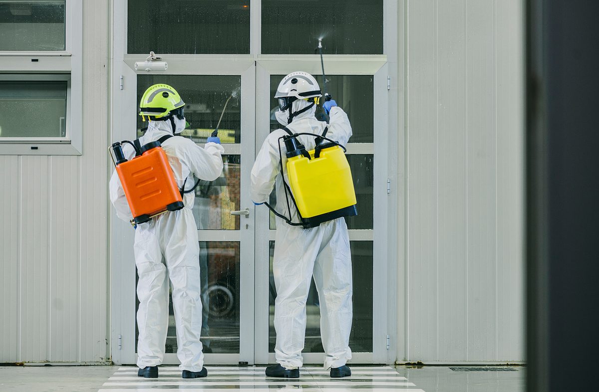 Two firefighters disinfecting the interior of a building