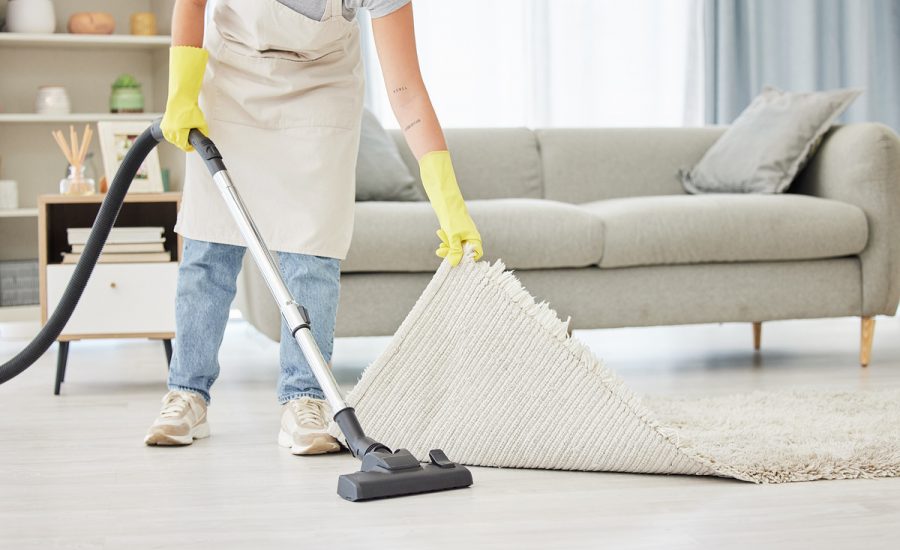 Carpet, person and vacuum with cleaner, home and remove dust for hygiene, bacteria and lounge. Dirt, worker and maid with cleaning equipment, mat and apartment with housekeeping and spring cleaning.