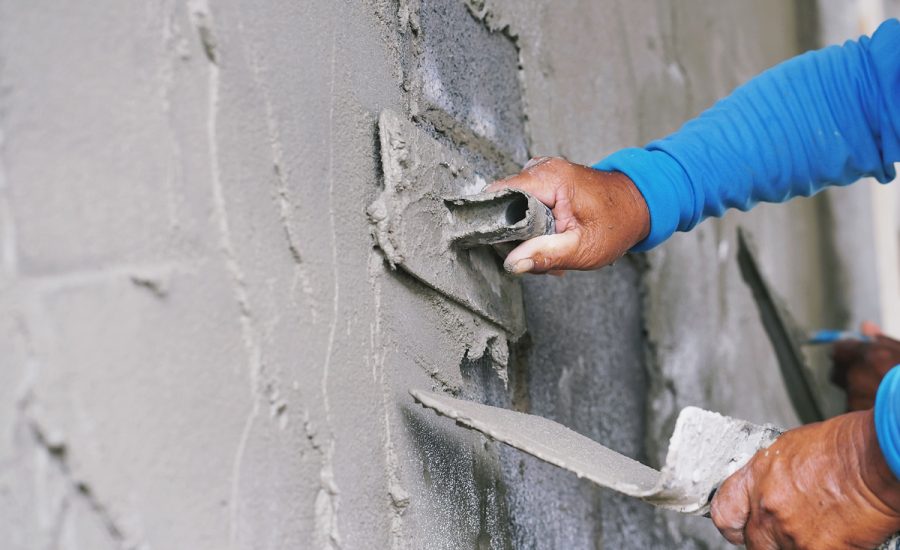 hand of worker plastering cement on wall