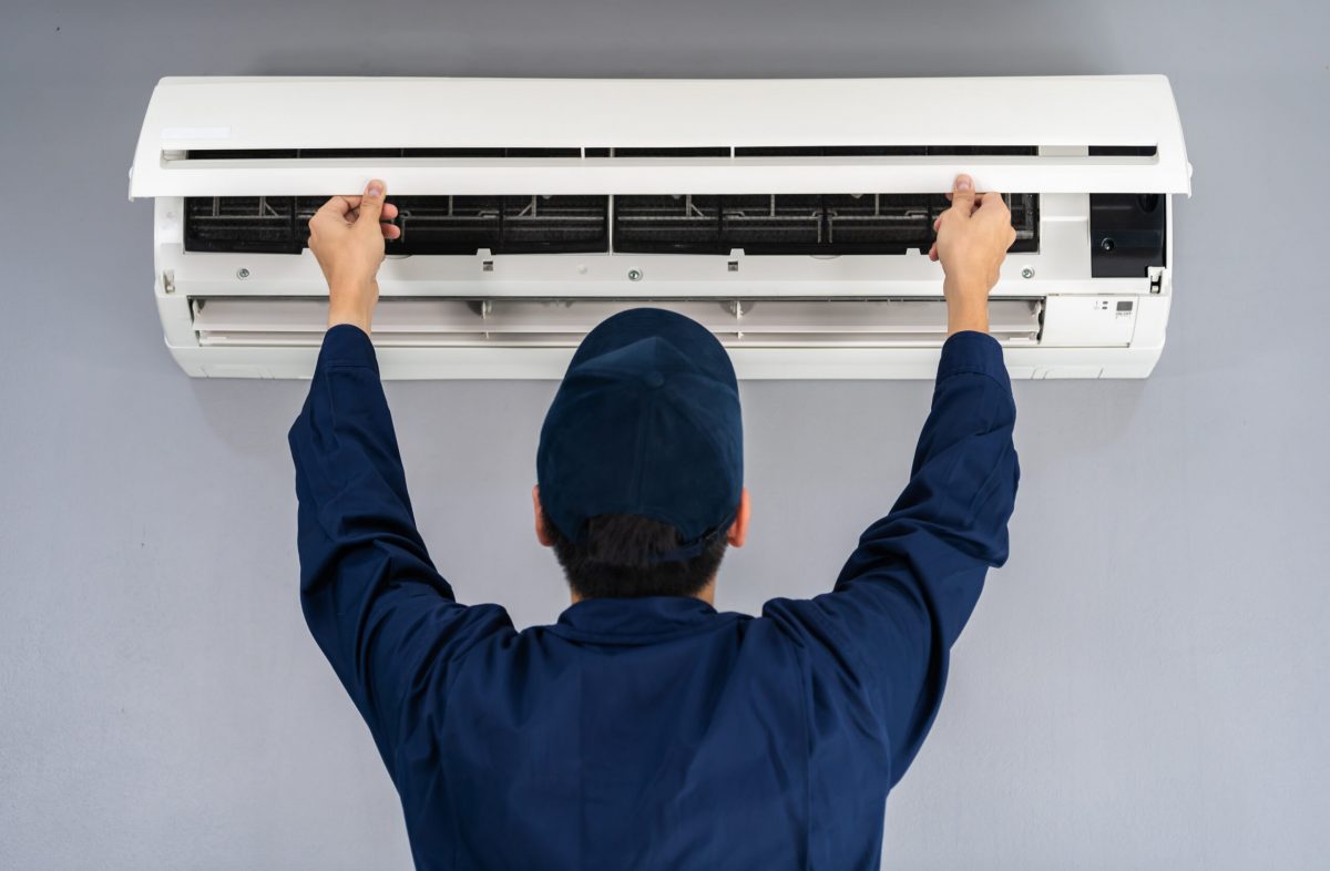 technician service checking and repairing air conditioner indoors